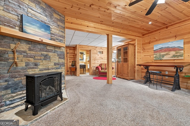 744 Dover Falls Trl, Ellijay, GA 30540 - recreation room with a wood stove, wooden walls, carpet, a ceiling fan, and wood ceiling