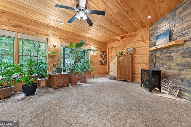 744 Dover Falls Trl, Ellijay, GA 30540 - carpeted living room with a wood stove, wood ceiling, ceiling fan, and wooden walls