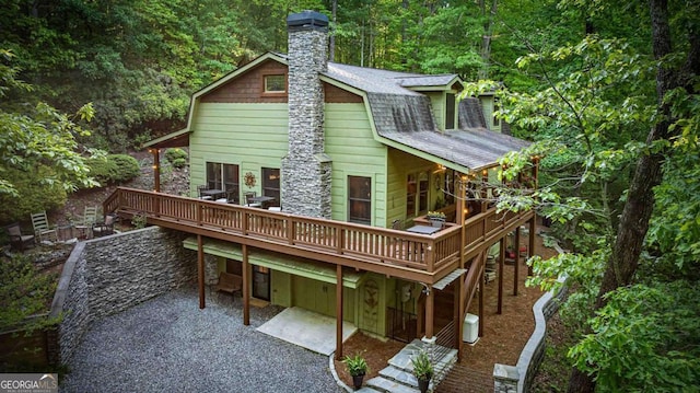 744 Dover Falls Trl, Ellijay, GA 30540 - back of house with a deck, a chimney, a patio, a gambrel roof, and roof with shingles