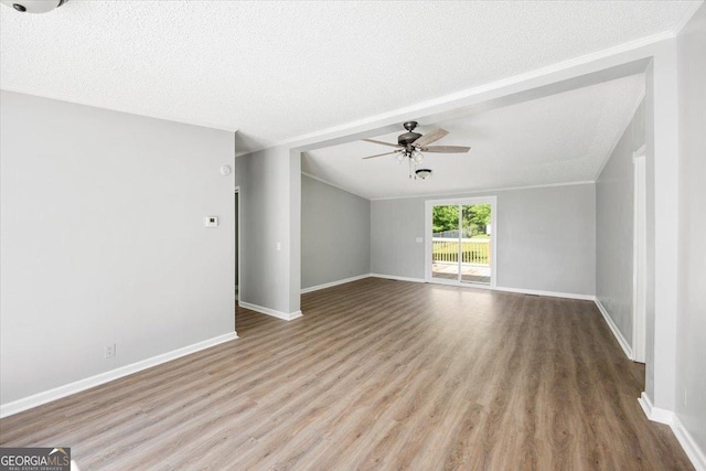 165 Forest Hill Dr, Eatonton, GA 31024 - unfurnished living room with ceiling fan, wood finished floors, baseboards, lofted ceiling, and a textured ceiling