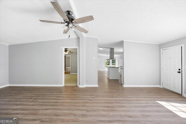 165 Forest Hill Dr, Eatonton, GA 31024 - unfurnished living room featuring a textured ceiling, ceiling fan, wood finished floors, baseboards, and crown molding