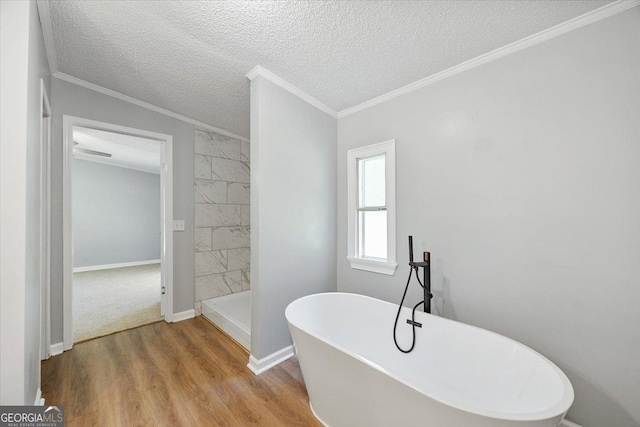 165 Forest Hill Dr, Eatonton, GA 31024 - full bath featuring a soaking tub, wood finished floors, a textured ceiling, baseboards, and crown molding