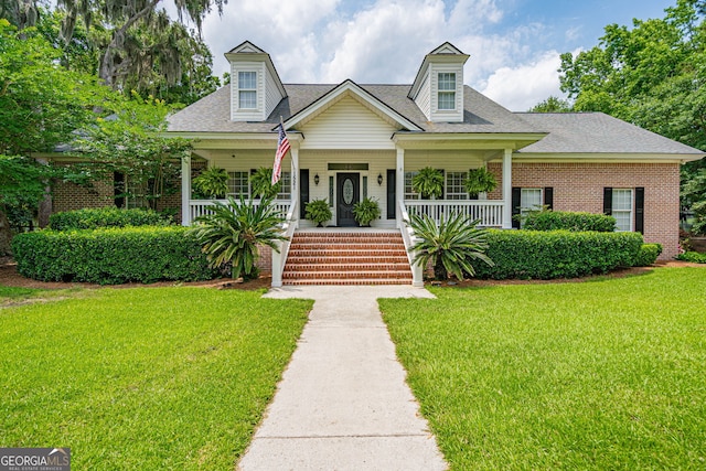 1521 Walthour Rd, Savannah, GA 31410 - cape cod house featuring a front lawn, brick siding, a porch, and a shingled roof
