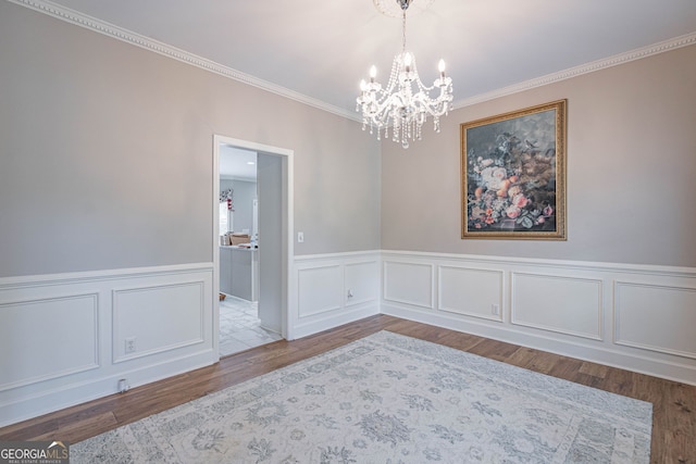 1521 Walthour Rd, Savannah, GA 31410 - empty room featuring a chandelier, ornamental molding, wood finished floors, a wainscoted wall, and a decorative wall