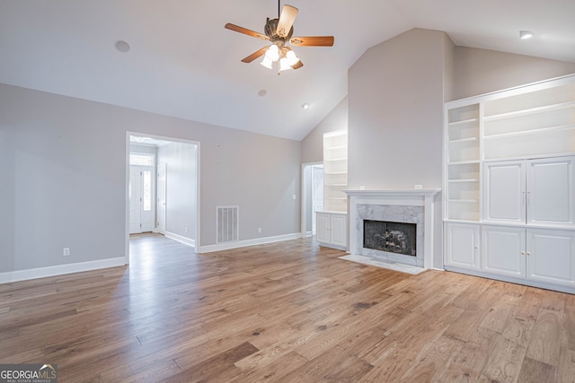 1521 Walthour Rd, Savannah, GA 31410 - unfurnished living room featuring a ceiling fan, light wood-style flooring, a premium fireplace, baseboards, and high vaulted ceiling