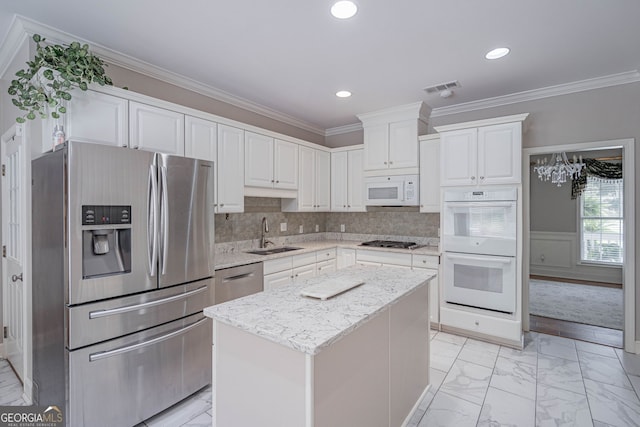 1521 Walthour Rd, Savannah, GA 31410 - kitchen with stainless steel appliances, a sink, light marble finish floors, white cabinetry, and a kitchen island