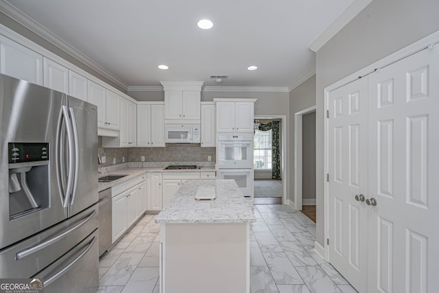 1521 Walthour Rd, Savannah, GA 31410 - kitchen with stainless steel appliances, light marble finish floors, ornamental molding, a center island, and white cabinets
