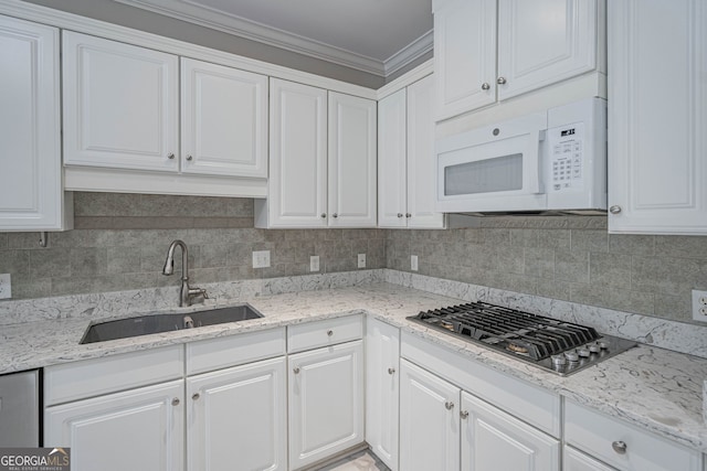 1521 Walthour Rd, Savannah, GA 31410 - kitchen with white microwave, a sink, stainless steel gas stovetop, white cabinets, and ornamental molding