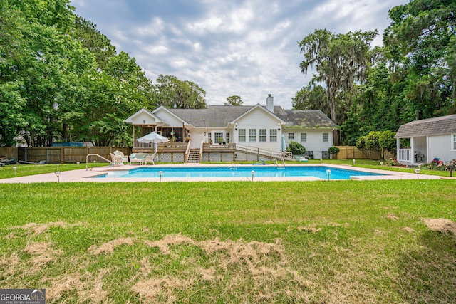 1521 Walthour Rd, Savannah, GA 31410 - view of swimming pool featuring a wooden deck, an outbuilding, and view of scattered trees