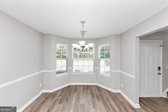 11827 Spring Lake Way, Fayetteville, GA 30215 - unfurnished dining area with wood finished floors, a chandelier, baseboards, and a textured ceiling