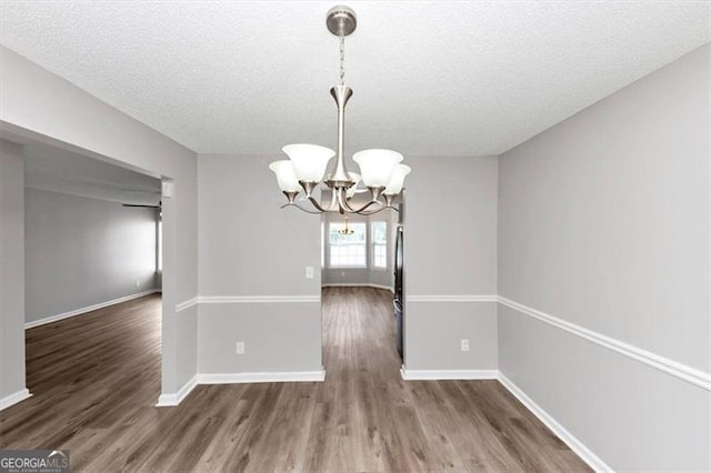 11827 Spring Lake Way, Fayetteville, GA 30215 - unfurnished dining area with a chandelier, a textured ceiling, wood finished floors, and baseboards
