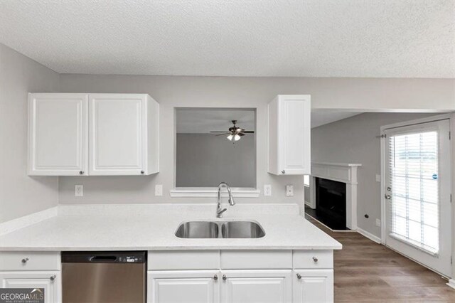11827 Spring Lake Way, Fayetteville, GA 30215 - kitchen with stainless steel dishwasher, a sink, ceiling fan, a fireplace with raised hearth, and light countertops