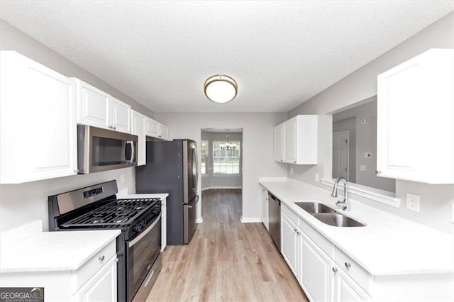 11827 Spring Lake Way, Fayetteville, GA 30215 - kitchen with appliances with stainless steel finishes, a sink, light wood-style flooring, white cabinets, and light countertops
