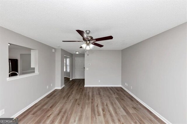 11827 Spring Lake Way, Fayetteville, GA 30215 - unfurnished living room featuring wood finished floors, a ceiling fan, baseboards, and a textured ceiling