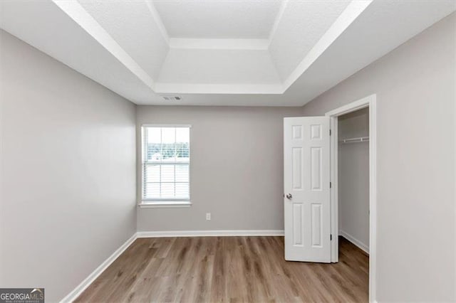 11827 Spring Lake Way, Fayetteville, GA 30215 - unfurnished bedroom featuring a raised ceiling, wood finished floors, and baseboards