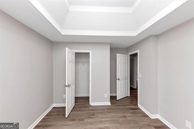 11827 Spring Lake Way, Fayetteville, GA 30215 - unfurnished bedroom featuring a raised ceiling, wood finished floors, baseboards, and a closet