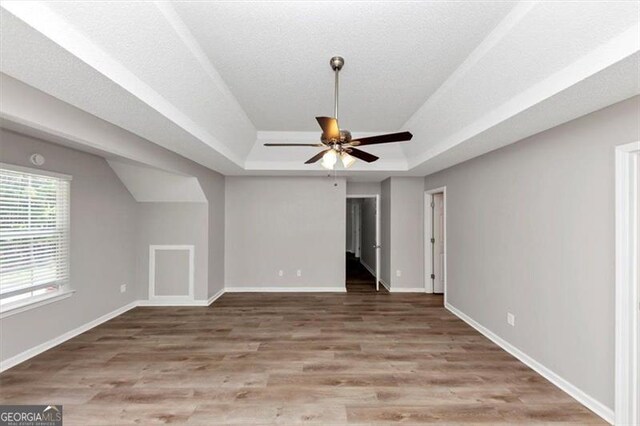 11827 Spring Lake Way, Fayetteville, GA 30215 - unfurnished living room with a raised ceiling, wood finished floors, a ceiling fan, and baseboards