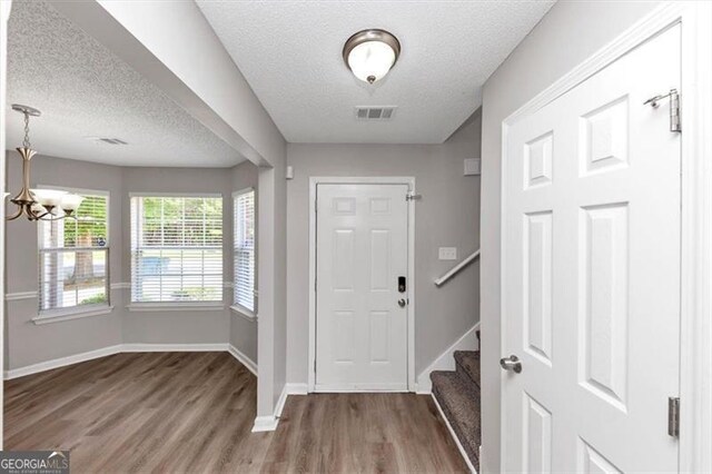 11827 Spring Lake Way, Fayetteville, GA 30215 - foyer with a textured ceiling, wood finished floors, a chandelier, baseboards, and stairway