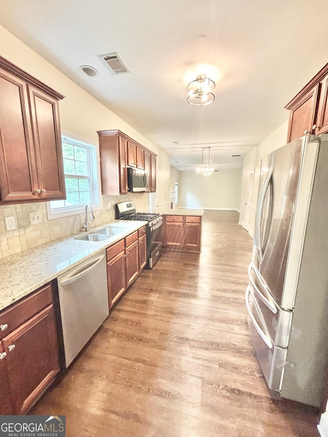 759 Hennepin Ter, Mcdonough, GA 30253 - kitchen featuring appliances with stainless steel finishes, a sink, wood finished floors, backsplash, and light stone countertops