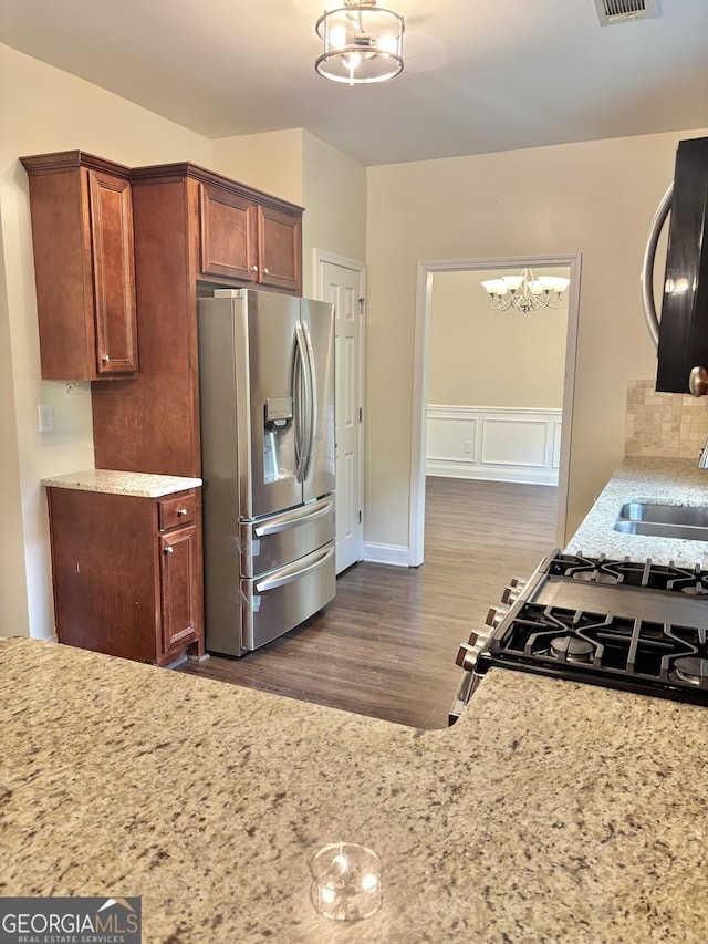 759 Hennepin Ter, Mcdonough, GA 30253 - kitchen with stainless steel appliances, a chandelier, a sink, dark wood-style floors, and light stone countertops