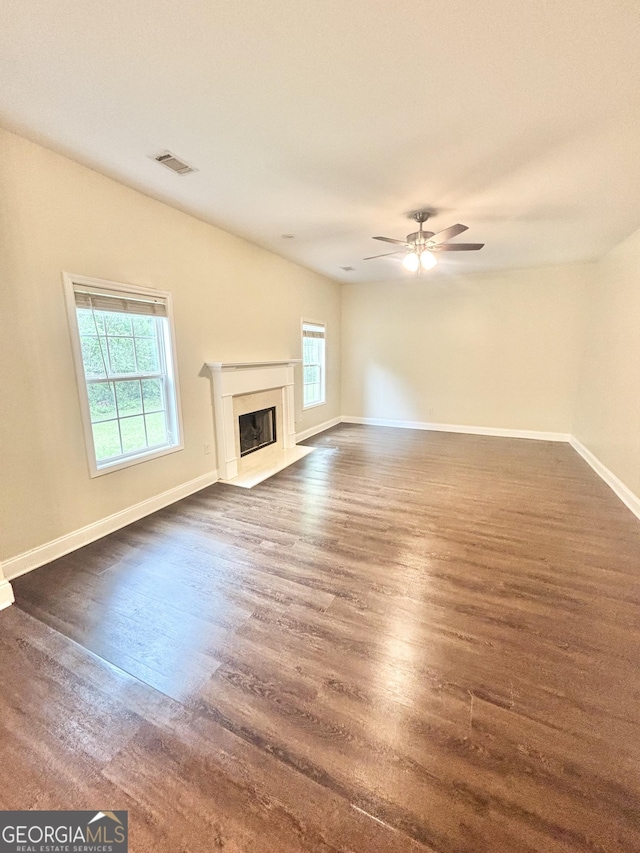 759 Hennepin Ter, Mcdonough, GA 30253 - unfurnished living room with dark wood-style floors, baseboards, a fireplace with flush hearth, and ceiling fan