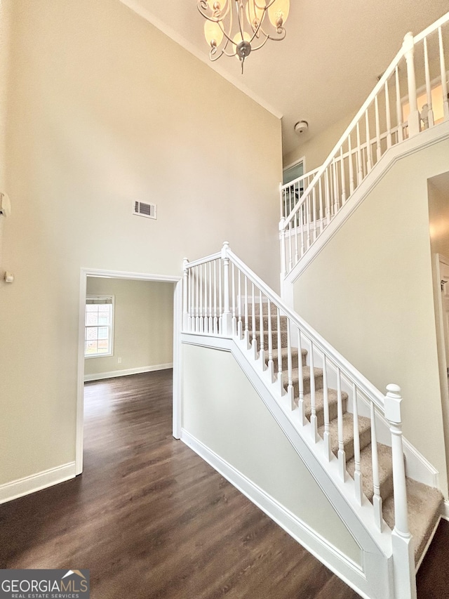 759 Hennepin Ter, Mcdonough, GA 30253 - stairs with a high ceiling, wood finished floors, a chandelier, and baseboards