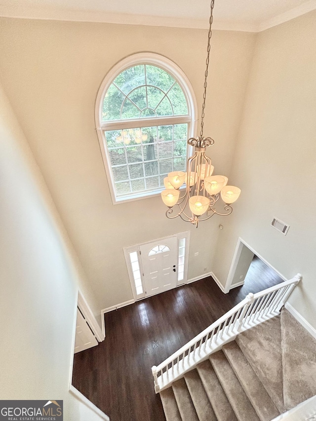 759 Hennepin Ter, Mcdonough, GA 30253 - foyer featuring a chandelier, wood finished floors, baseboards, crown molding, and a towering ceiling