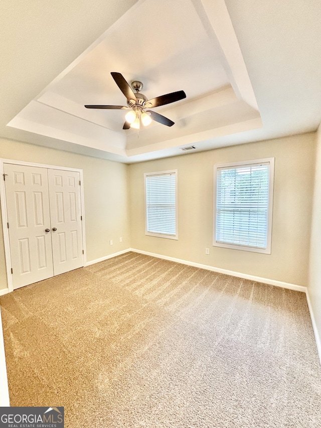 759 Hennepin Ter, Mcdonough, GA 30253 - unfurnished bedroom with a raised ceiling, baseboards, carpet flooring, a closet, and a ceiling fan