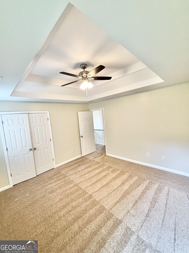759 Hennepin Ter, Mcdonough, GA 30253 - unfurnished bedroom featuring a raised ceiling, baseboards, carpet flooring, a closet, and ceiling fan