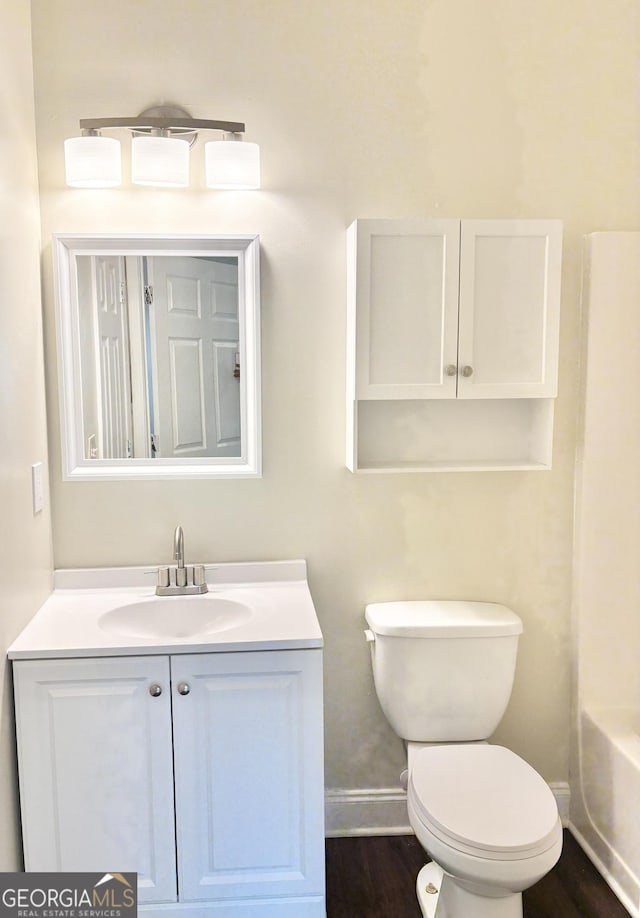 759 Hennepin Ter, Mcdonough, GA 30253 - bathroom with baseboards, vanity, toilet, and wood finished floors