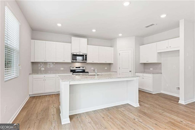 7193 Brushwood Bnd, Lithonia, GA 30058 - kitchen featuring stainless steel appliances, tasteful backsplash, white cabinets, light wood-style floors, and recessed lighting