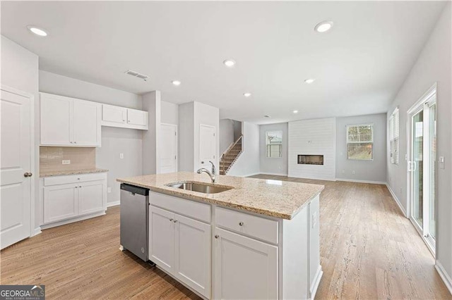 7193 Brushwood Bnd, Lithonia, GA 30058 - kitchen with a sink, dishwasher, white cabinetry, light stone counters, and recessed lighting