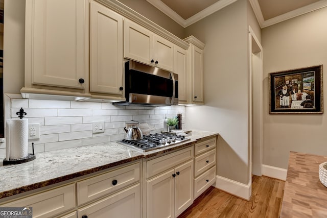 3715 Horizon Ct, Cumming, GA 30041 - kitchen with stainless steel appliances, light wood-type flooring, ornamental molding, tasteful backsplash, and light stone counters