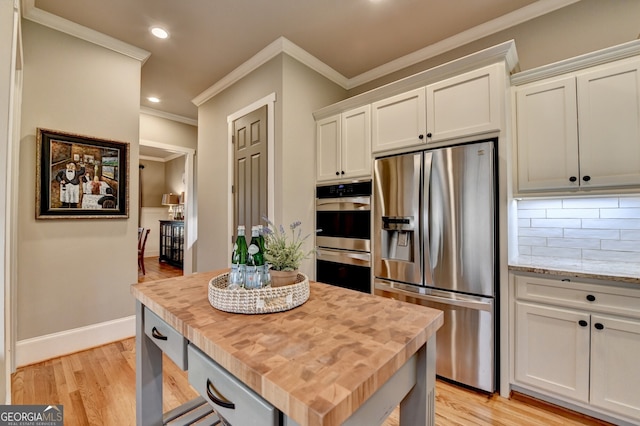 3715 Horizon Ct, Cumming, GA 30041 - kitchen with stainless steel appliances, butcher block countertops, crown molding, light wood finished floors, and recessed lighting