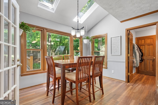 1850 Linnet Ct NE, Roswell, GA 30075 - dining space with a skylight, vaulted ceiling, wood finished floors, and baseboards
