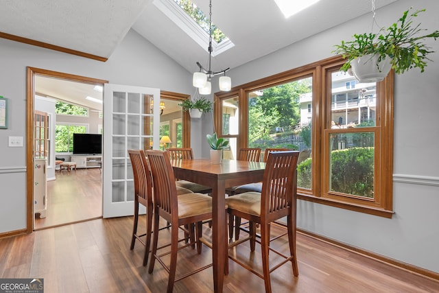 1850 Linnet Ct NE, Roswell, GA 30075 - dining area featuring vaulted ceiling, wood finished floors, a skylight, a chandelier, and baseboards