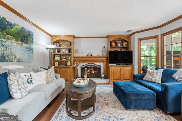 1850 Linnet Ct NE, Roswell, GA 30075 - living area with wood finished floors, built in shelves, a textured ceiling, crown molding, and a warm lit fireplace