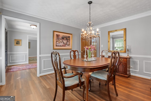 1850 Linnet Ct NE, Roswell, GA 30075 - dining space with wood finished floors, a chandelier, a decorative wall, a textured ceiling, and a wainscoted wall