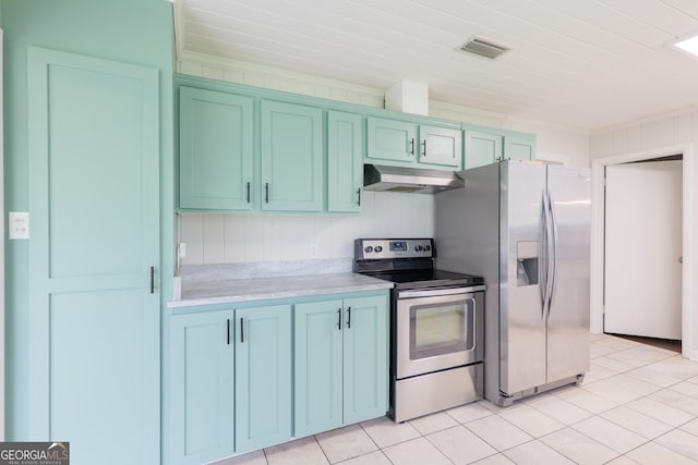 215 E Main St, Hahira, GA 31632 - kitchen featuring appliances with stainless steel finishes, under cabinet range hood, light countertops, light tile patterned flooring, and blue cabinets