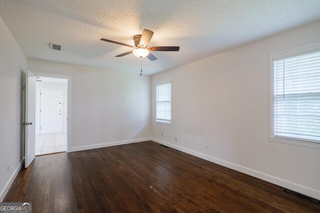215 E Main St, Hahira, GA 31632 - spare room featuring ceiling fan, dark wood finished floors, baseboards, and a textured ceiling