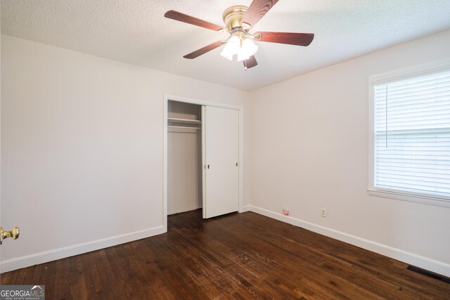 215 E Main St, Hahira, GA 31632 - unfurnished bedroom with dark wood-style flooring, baseboards, and a closet