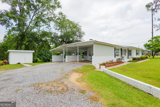 215 E Main St, Hahira, GA 31632 - view of front of property featuring gravel driveway, a carport, and a front yard
