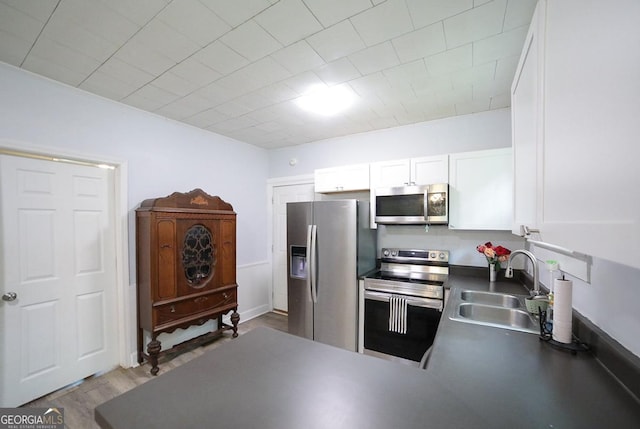 430 Sherwood Cir, Danielsville, GA 30633 - kitchen featuring appliances with stainless steel finishes, dark countertops, white cabinetry, a peninsula, and wood finished floors