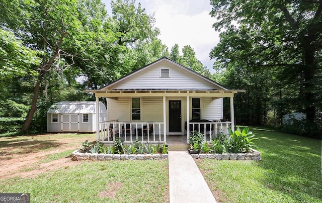 430 Sherwood Cir, Danielsville, GA 30633 - bungalow-style house featuring a porch, a front yard, a storage unit, and view of scattered trees