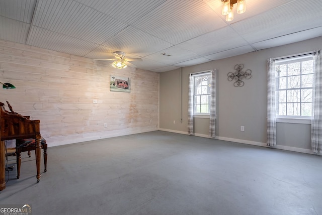157 Riverbend Cir, Royston, GA 30662 - empty room with wood walls, a ceiling fan, and concrete flooring