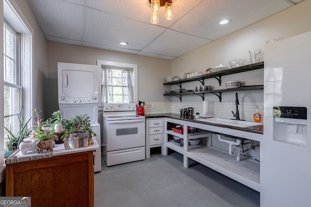 157 Riverbend Cir, Royston, GA 30662 - kitchen featuring white appliances, stacked washer / drying machine, concrete floors, open shelves, and decorative backsplash