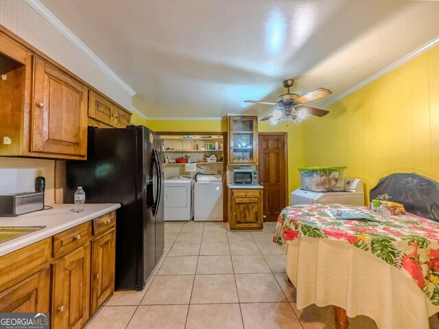 2000 Stone Mountain Lithonia Rd, Lithonia, GA 30058 - kitchen with washing machine and dryer, stainless steel microwave, crown molding, brown cabinetry, and a ceiling fan