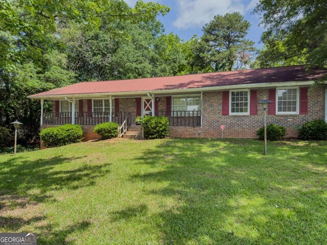2000 Stone Mountain Lithonia Rd, Lithonia, GA 30058 - ranch-style home featuring covered porch, brick siding, and a front lawn