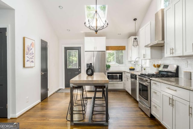 936 Ormewood Ter SE, Atlanta, GA 30316 - kitchen featuring appliances with stainless steel finishes, wall chimney exhaust hood, decorative backsplash, a chandelier, and recessed lighting