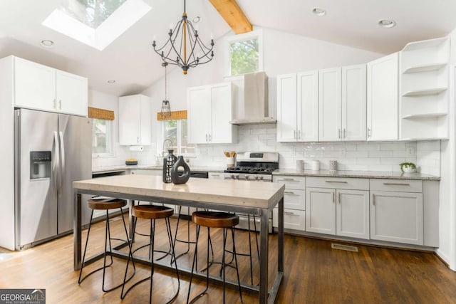 936 Ormewood Ter SE, Atlanta, GA 30316 - kitchen with appliances with stainless steel finishes, wall chimney exhaust hood, a skylight, pendant lighting, and white cabinetry
